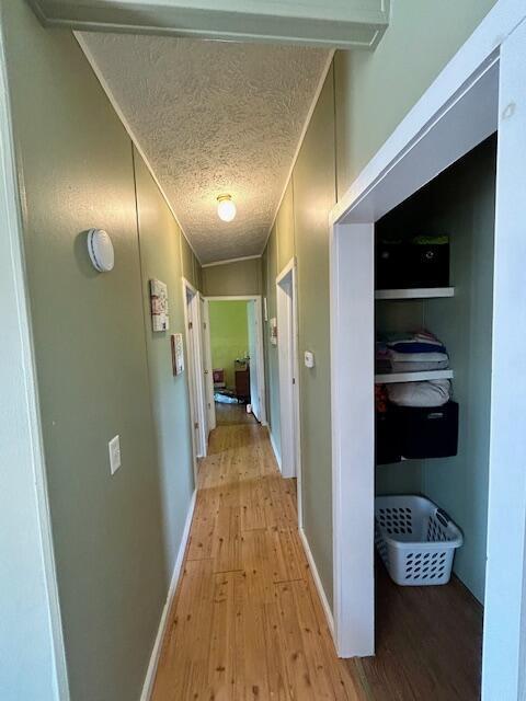 9330 Pidcock Rd, Zanesville, OH 43701 - hallway featuring light wood-style flooring, a textured ceiling, and baseboards