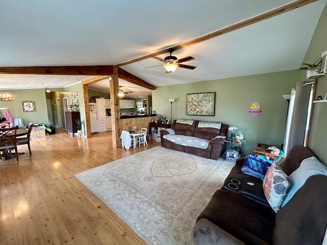9330 Pidcock Rd, Zanesville, OH 43701 - living area with wood finished floors, vaulted ceiling with beams, and ceiling fan with notable chandelier
