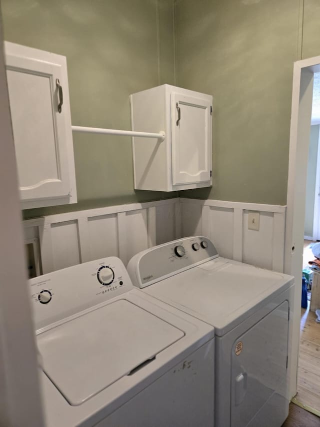 9330 Pidcock Rd, Zanesville, OH 43701 - laundry area featuring cabinet space, washing machine and clothes dryer, a decorative wall, a wainscoted wall, and wood finished floors