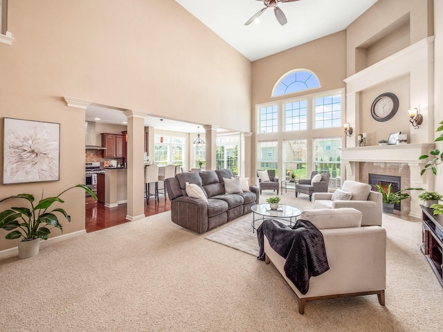 7766 Dickens Ct, Delaware, OH 43015 - living room featuring a towering ceiling, ornate columns, a ceiling fan, carpet floors, and a fireplace