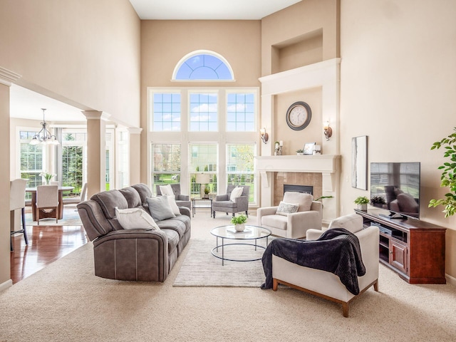 7766 Dickens Ct, Delaware, OH 43015 - living area with a tile fireplace, a high ceiling, a chandelier, and decorative columns