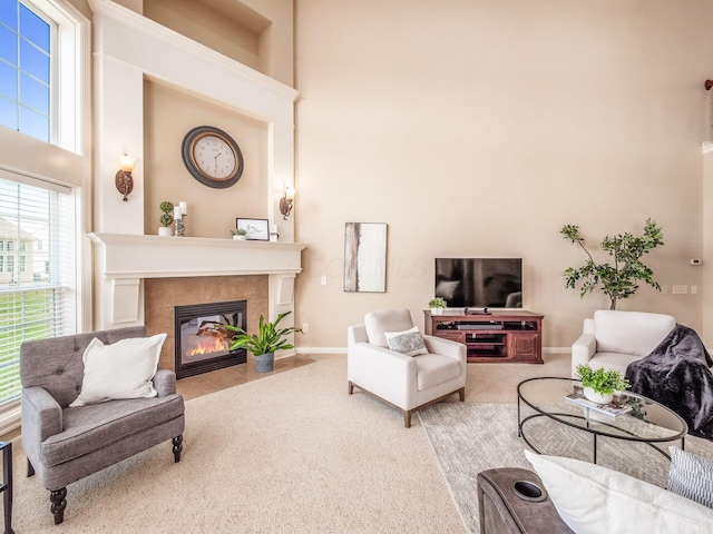 7766 Dickens Ct, Delaware, OH 43015 - carpeted living room featuring a tiled fireplace, a towering ceiling, and baseboards