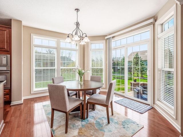 7766 Dickens Ct, Delaware, OH 43015 - dining room with hardwood / wood-style flooring, baseboards, and a notable chandelier