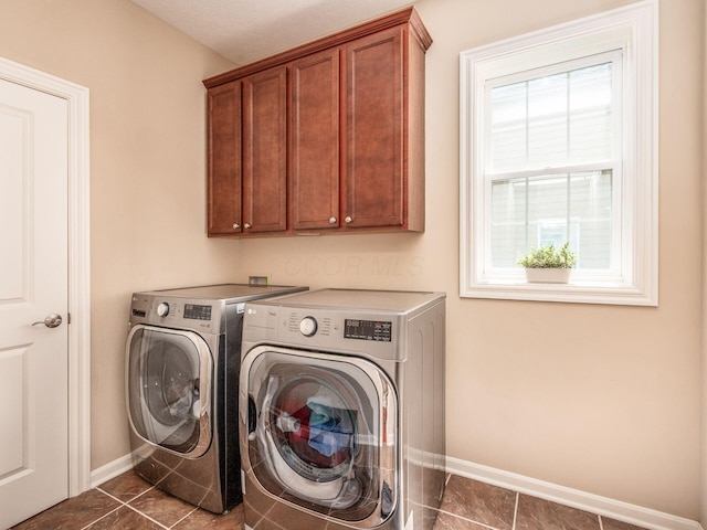 7766 Dickens Ct, Delaware, OH 43015 - washroom with dark tile patterned flooring, baseboards, washer and dryer, and cabinet space
