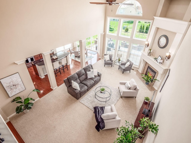 7766 Dickens Ct, Delaware, OH 43015 - living room with a high end fireplace, a wealth of natural light, a towering ceiling, and a ceiling fan