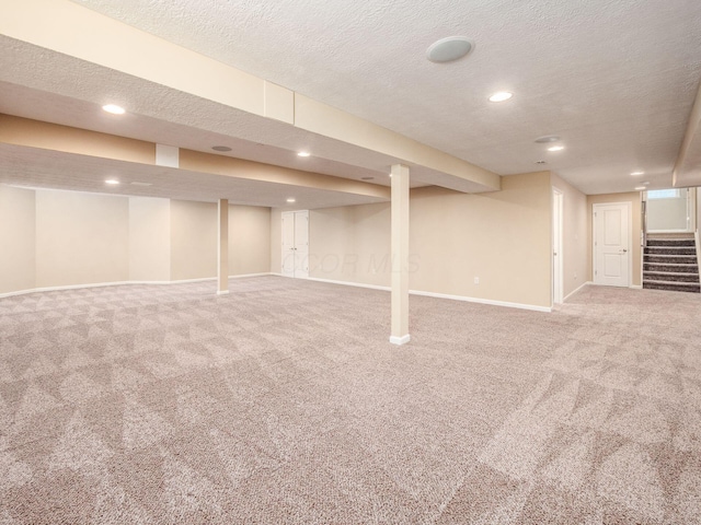 7766 Dickens Ct, Delaware, OH 43015 - finished basement with carpet flooring, a textured ceiling, baseboards, recessed lighting, and stairway