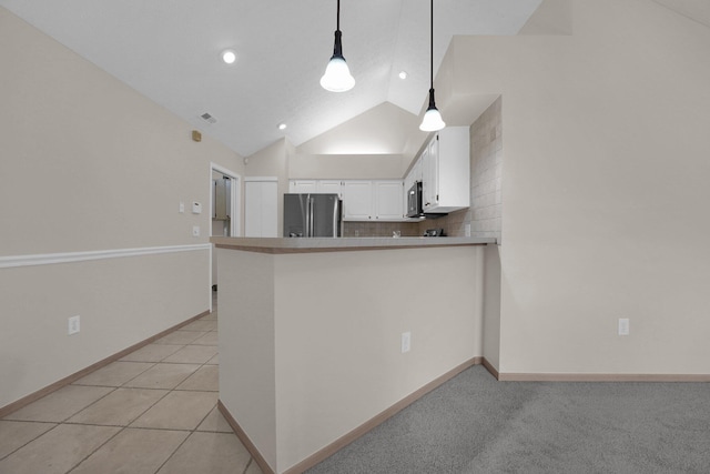 5585 Meadowood Ln, Westerville, OH 43082 - kitchen with white cabinetry, a peninsula, vaulted ceiling, backsplash, and appliances with stainless steel finishes