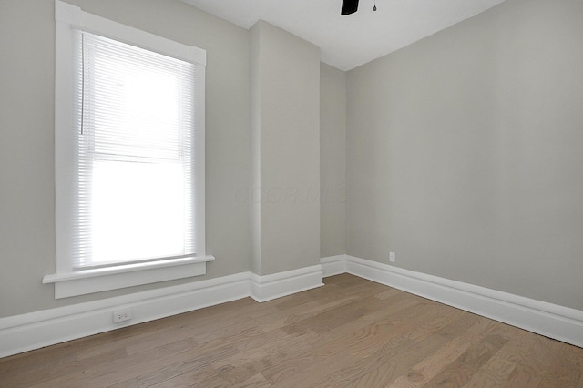 spare room featuring baseboards, a ceiling fan, and wood finished floors