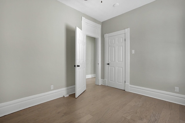 unfurnished bedroom with baseboards and wood finished floors