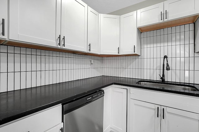 kitchen featuring a sink, dark countertops, backsplash, white cabinetry, and dishwasher