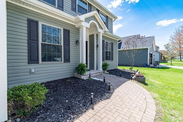 entrance to property with a lawn