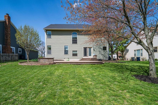 rear view of property with a lawn and fence