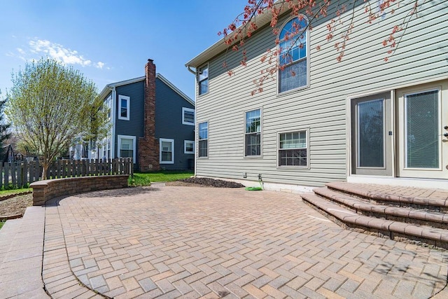 rear view of property with fence and a patio