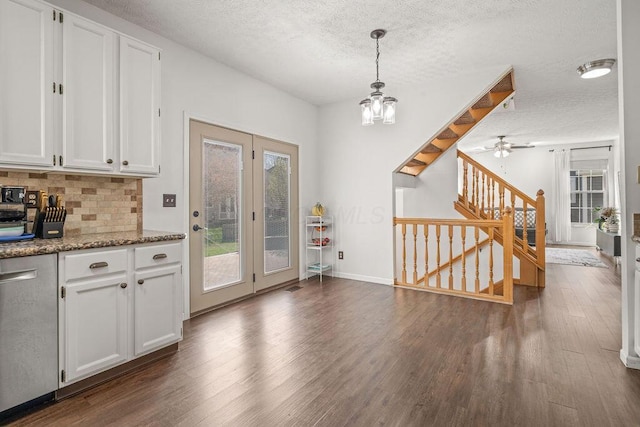 interior space featuring ceiling fan with notable chandelier, a textured ceiling, stairway, and dark wood finished floors