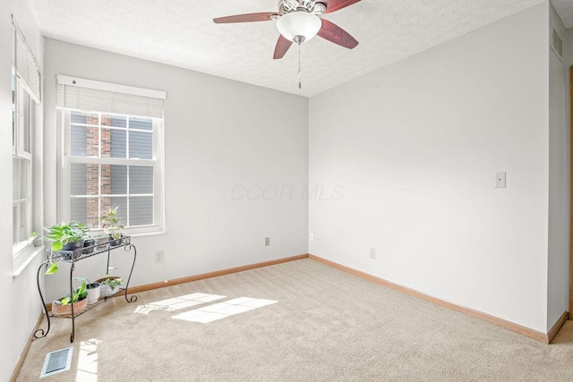 empty room with a textured ceiling, visible vents, and carpet flooring