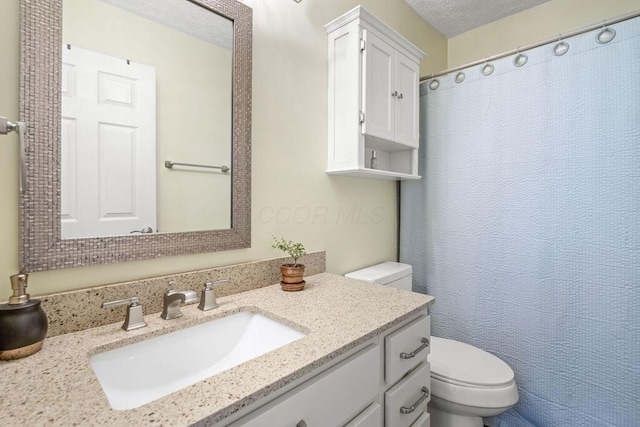 bathroom with vanity, a shower with shower curtain, and toilet