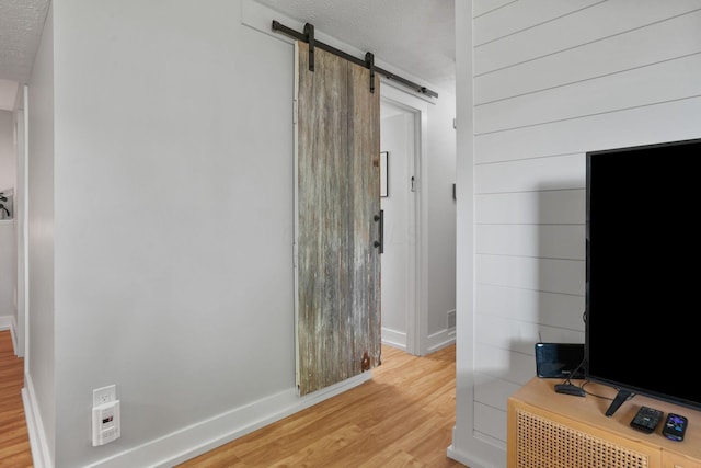 5133 Hidden View Dr, Hilliard, OH 43026 - hall with light wood finished floors, a textured ceiling, a barn door, and baseboards