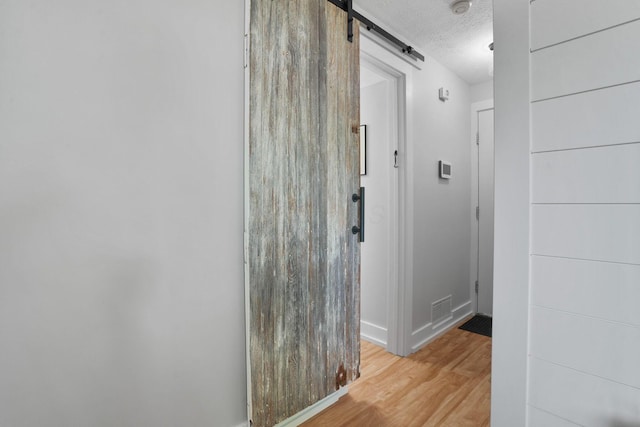 5133 Hidden View Dr, Hilliard, OH 43026 - corridor featuring a textured ceiling, wood finished floors, baseboards, and a barn door