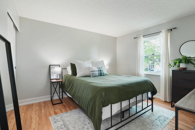5133 Hidden View Dr, Hilliard, OH 43026 - bedroom with light wood finished floors, baseboards, and a textured ceiling