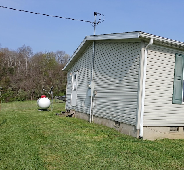 view of side of property featuring crawl space and a yard