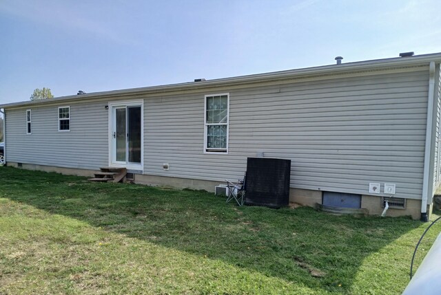 back of house with a lawn and entry steps