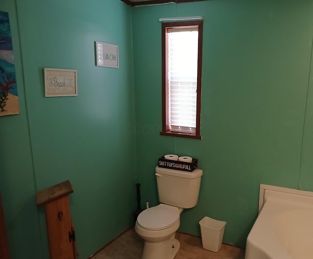 bathroom featuring toilet, a bathing tub, and tile patterned floors