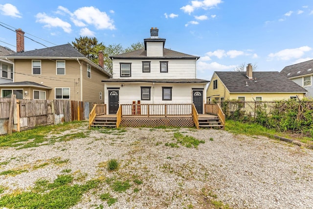 rear view of house with a deck and a fenced backyard