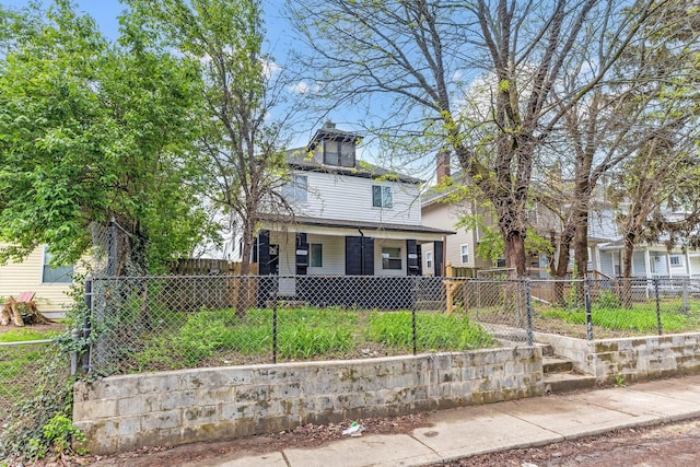 traditional style home with covered porch and a fenced front yard