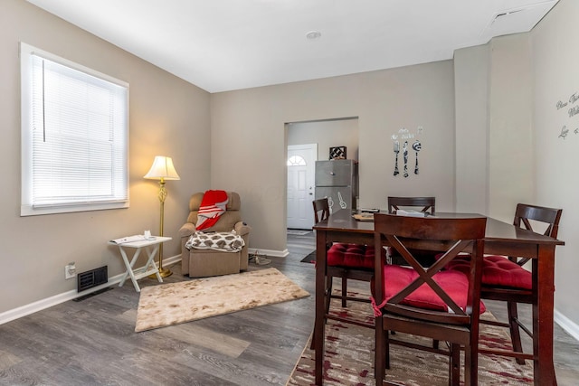 dining space featuring wood finished floors, visible vents, and baseboards