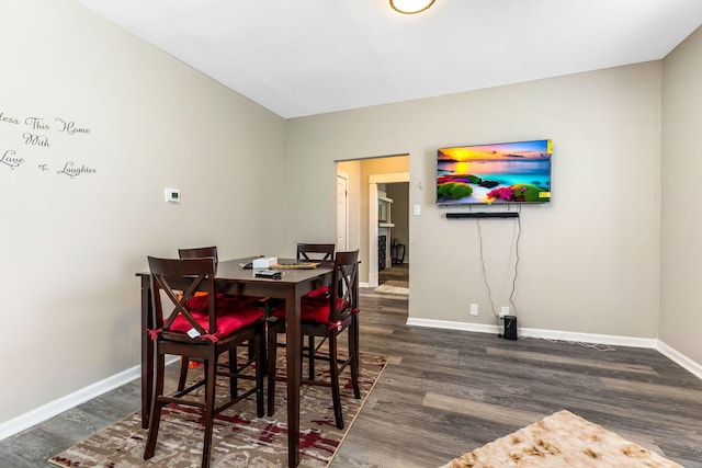 dining area with baseboards and wood finished floors
