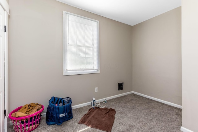 spare room with baseboards and carpet floors