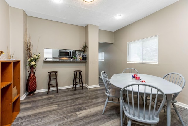 dining room featuring dark wood-style flooring and baseboards