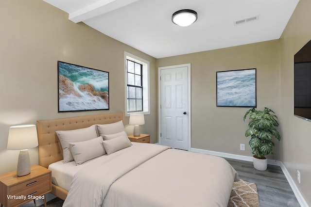 bedroom featuring wood finished floors, visible vents, and baseboards