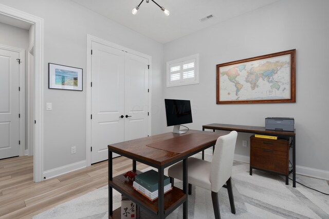 office space featuring baseboards, visible vents, and light wood-style flooring