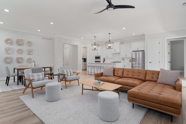 living area with crown molding, ceiling fan, recessed lighting, and visible vents