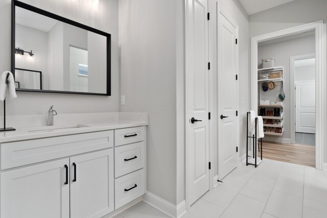 bathroom featuring a closet, baseboards, tile patterned flooring, and vanity