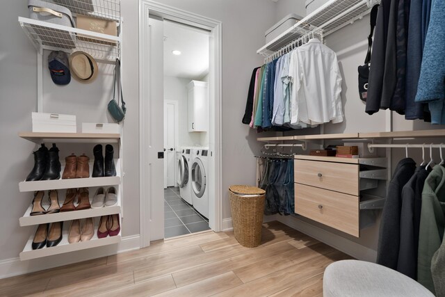 spacious closet featuring light wood-type flooring and washer and dryer