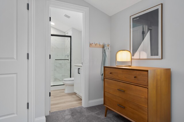full bathroom with vanity, a marble finish shower, vaulted ceiling, and toilet