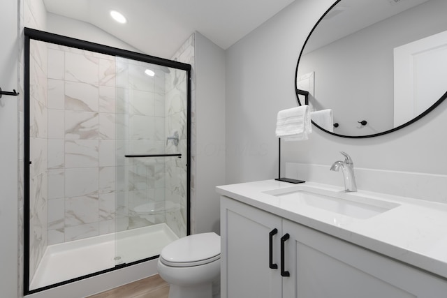 bathroom with vanity, wood finished floors, toilet, recessed lighting, and a stall shower