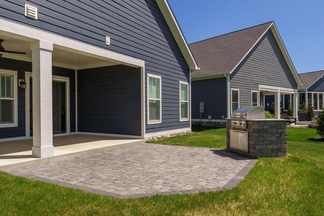 back of house with ceiling fan, a yard, a patio area, and area for grilling