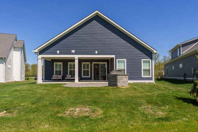 rear view of property with a yard and a patio area