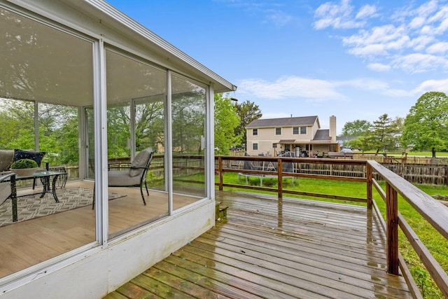 wooden terrace with a sunroom and fence