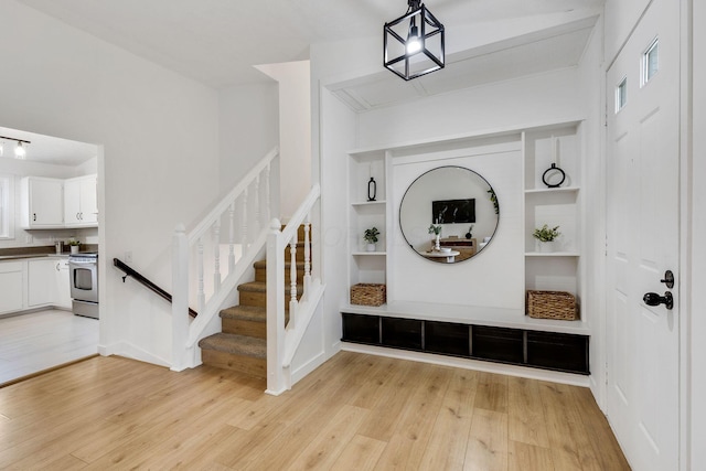 mudroom with light wood-type flooring and built in features