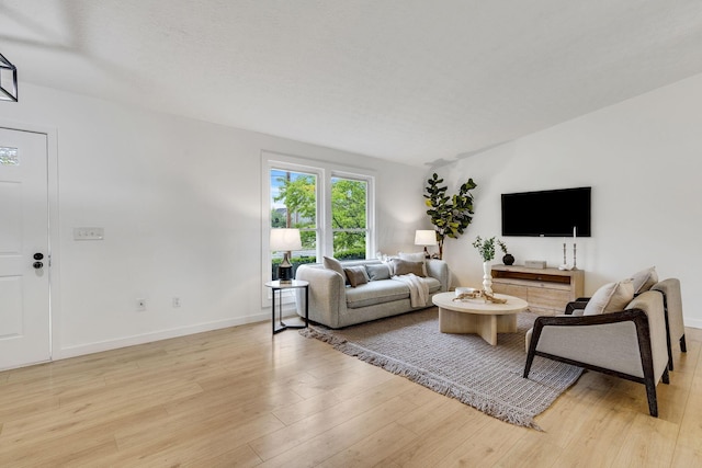 living room with light wood-style flooring and baseboards