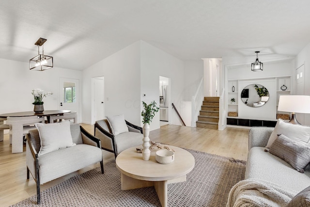 living room featuring light wood-type flooring and stairs