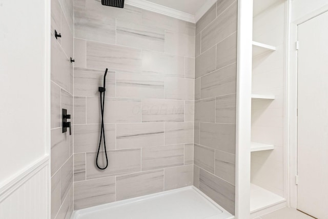 full bath featuring a tile shower and crown molding