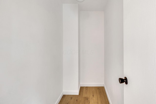 spare room featuring light wood-style floors and baseboards