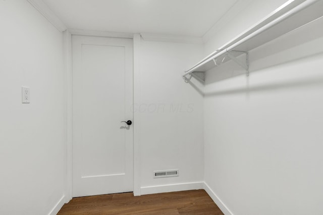 walk in closet with dark wood-type flooring