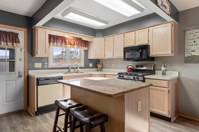 5796 Thada Ln, Columbus, OH 43229 - kitchen with light wood-style flooring, light brown cabinetry, gas range, black microwave, and dishwasher