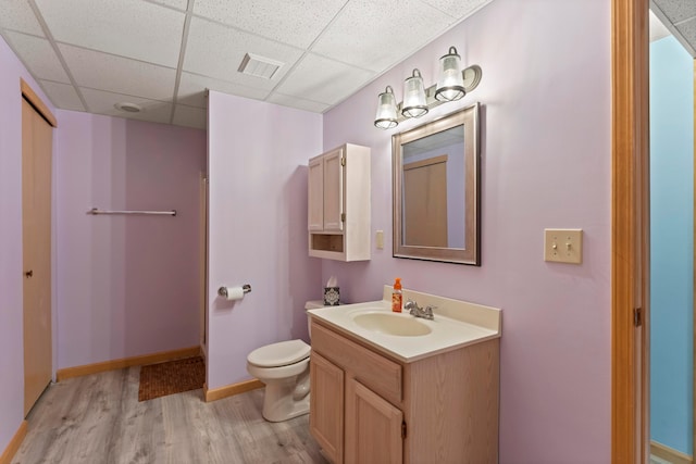 5796 Thada Ln, Columbus, OH 43229 - full bathroom featuring wood finished floors, vanity, toilet, visible vents, and a paneled ceiling